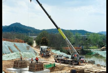 pexels photo 23379695 23379695 Active construction site featuring crane operation and workers amid a natural landscape.
