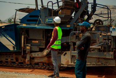 pexels photo 31674013 31674013 Two construction workers observing roadwork machinery under bright daylight.